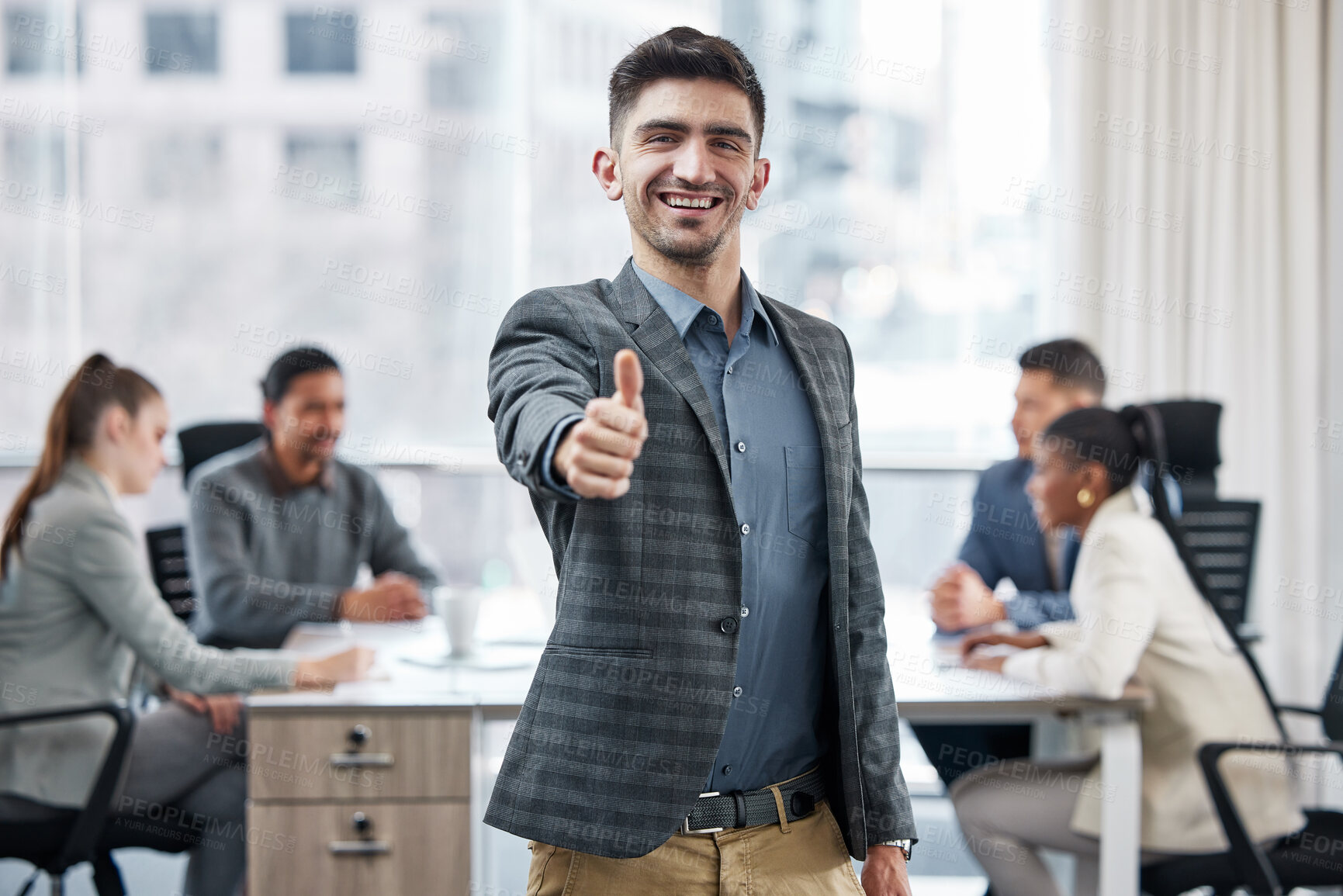 Buy stock photo Shot of a young businessman showing a thumbs up while in a meeting at work