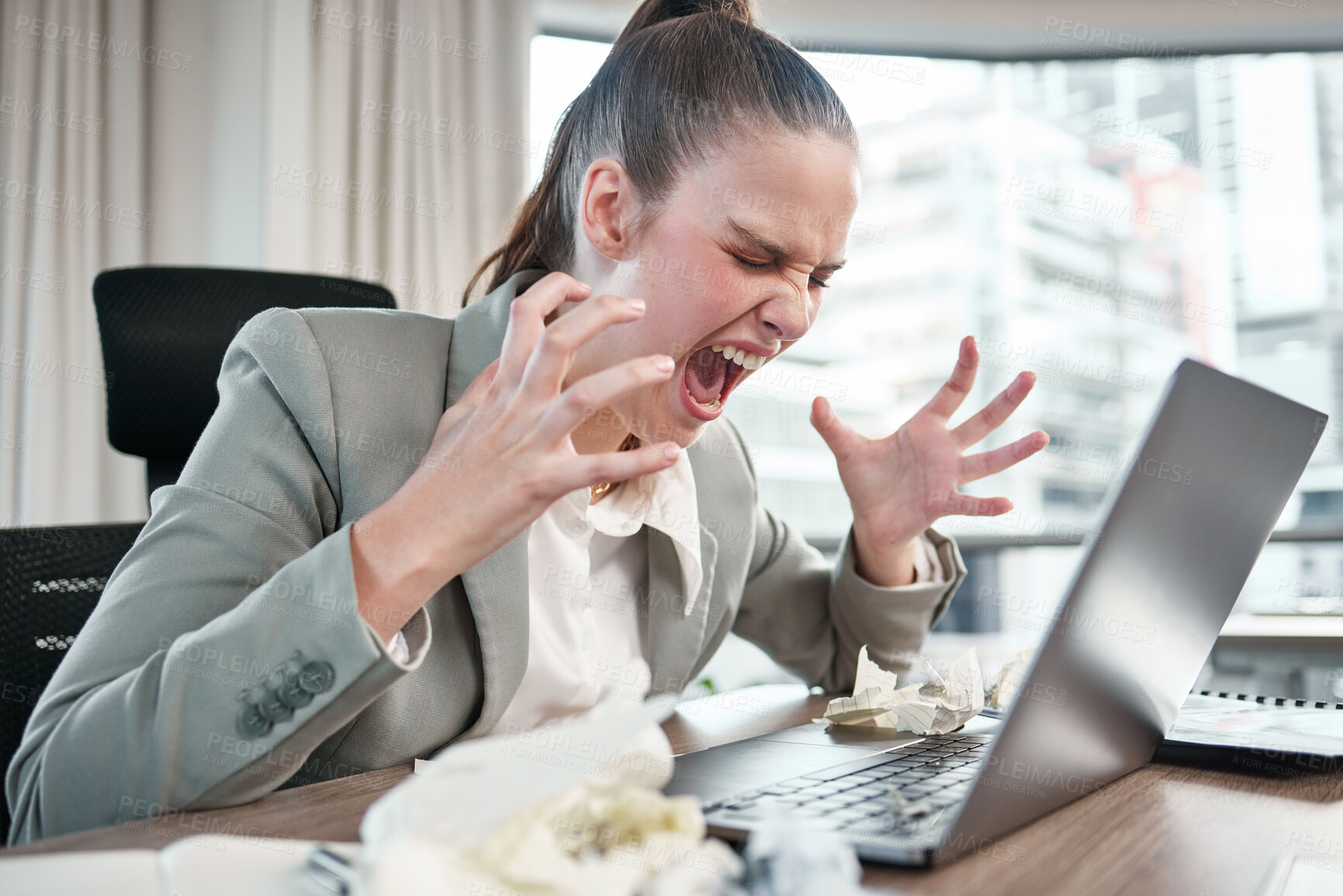 Buy stock photo Shot of a young businesswoman yelling while using a laptop in an office at work