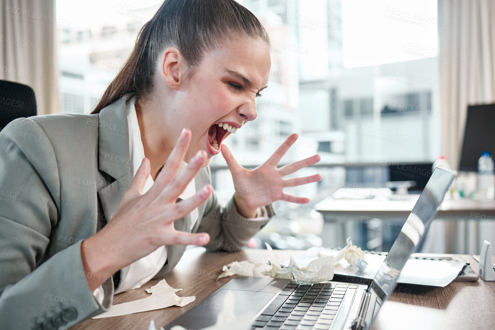 Buy stock photo Shot of a young businesswoman yelling while using a laptop in an office at work