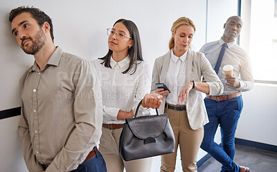 Buy stock photo Shot of a group of businesspeople waiting in line in an office at work