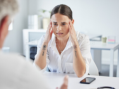 Buy stock photo Shot of a young woman suffering from a headache at the doctor's office