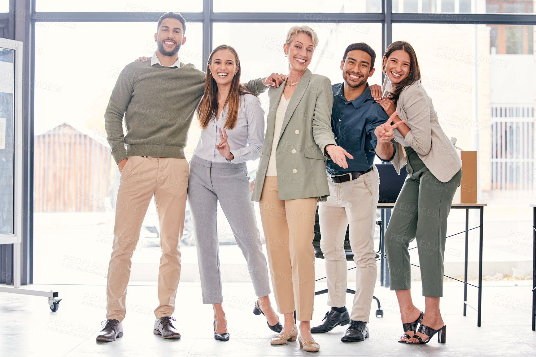 Buy stock photo Full length shot of a diverse group of businesspeople standing together and feeling playful in the office