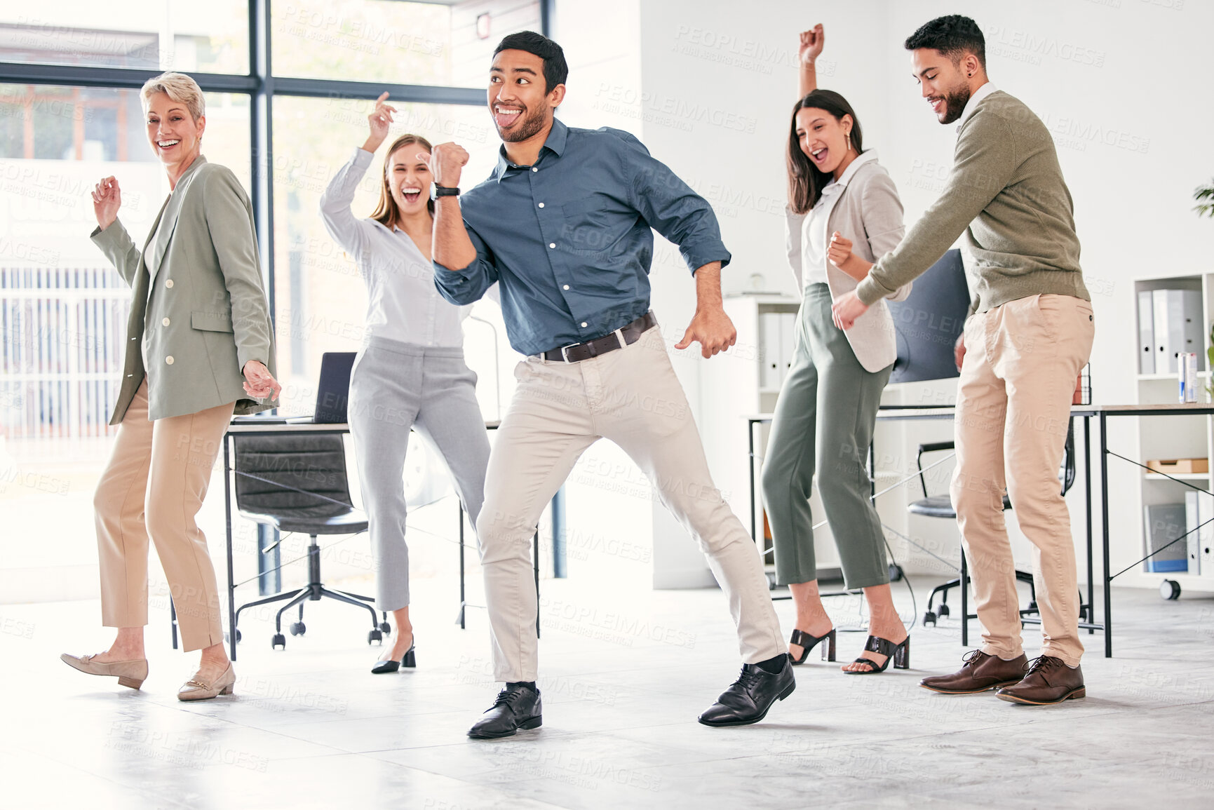 Buy stock photo Full length shot of a diverse group of businesspeople standing together and dancing in the office
