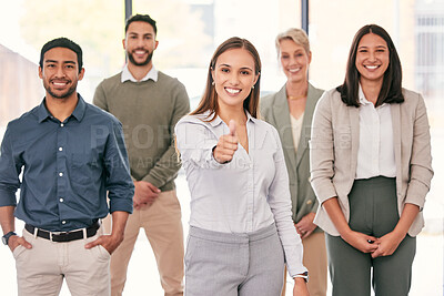 Buy stock photo Shot of an attractive young businesswoman standing in the office with her colleagues and showing a thumbs up