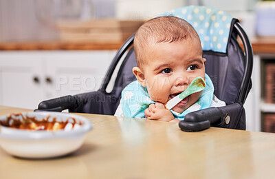 Buy stock photo Shot of an adorable baby boy looking happy while eating a meal