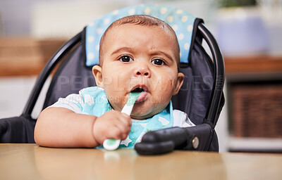 Buy stock photo Shot of an adorable baby boy sitting in his feeding chair with a spoon in his mouth