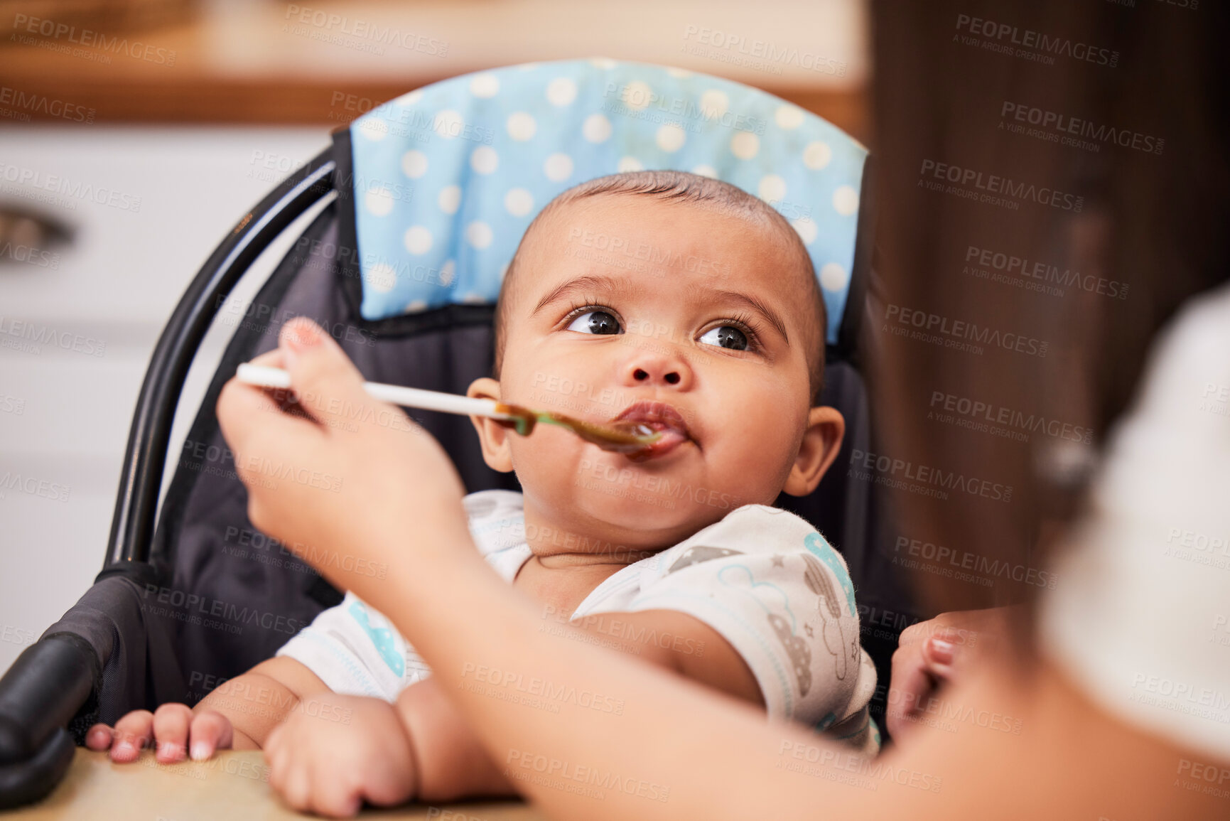 Buy stock photo Mom, feeding and face of baby with spoon, food and health for growth, child development and breakfast in high chair. Diet, nutrition and infant at table with woman for morning eating schedule in home