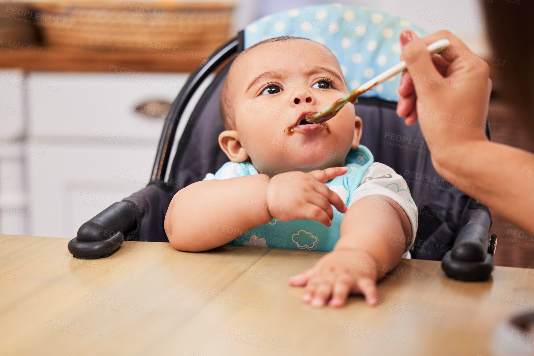 Buy stock photo Mom, hand and feeding baby in kitchen for nutrition, healthy diet or open mouth for food in home. Hungry infant, kid and parent with spoon at high chair for eating breakfast, growth and development