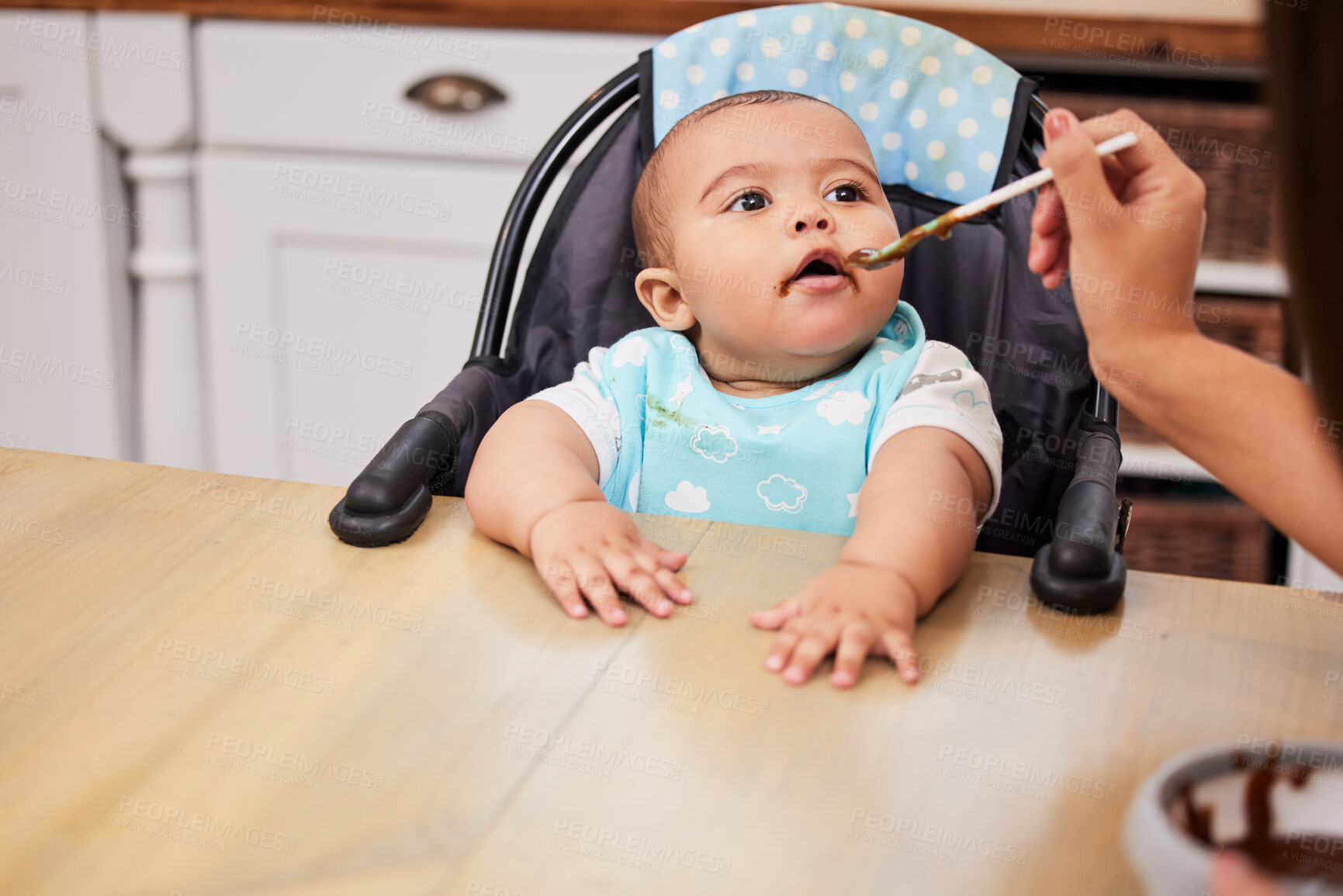 Buy stock photo Mother, hand and feeding baby in kitchen for nutrition, healthy diet or open mouth for food in home. Hungry infant, kid or parent with spoon at high chair for eating breakfast, growth and development