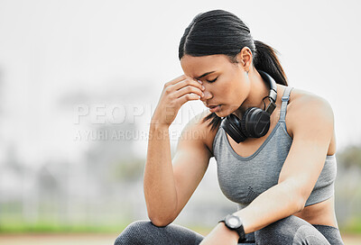 Buy stock photo Cropped shot of an attractive young female athlete looking stressed while exercising outside