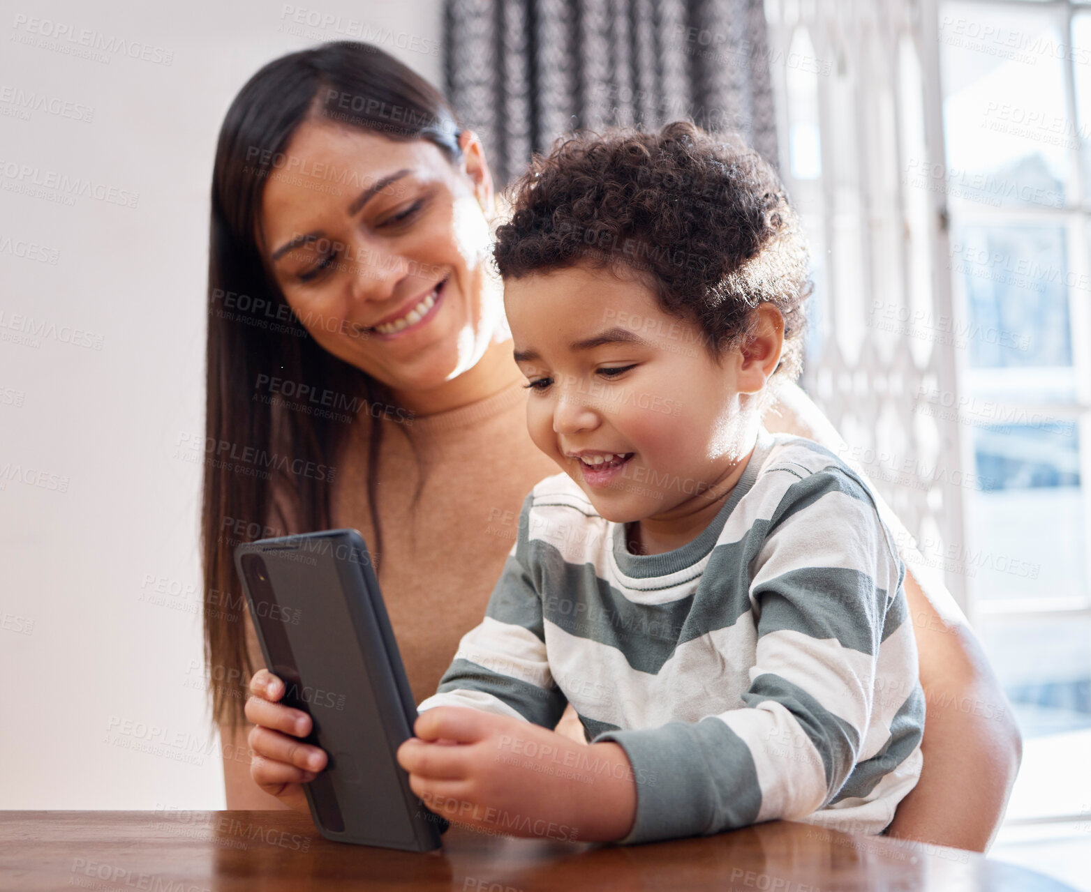 Buy stock photo Home, woman and toddler with phone by table for online education games, website and child development. Family, mother and son with technology in house for digital learning, entertainment or knowledge