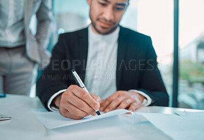 Buy stock photo Shot of a young businessman signing a contract in a office