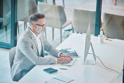 Buy stock photo Shot of a mature man using a computer at work in a office