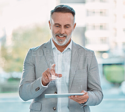 Buy stock photo Shot of an mature businessman sitting alone and using a tablet with graphical images in a office