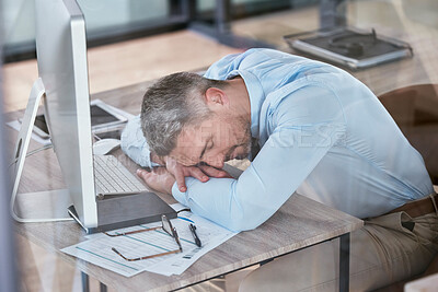 Buy stock photo Shot of a mature businessman sleeping at his desk in an office