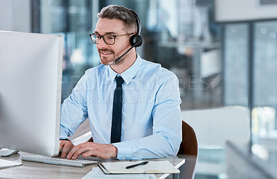 Buy stock photo Shot of a mature call centre agent working on a computer in an office