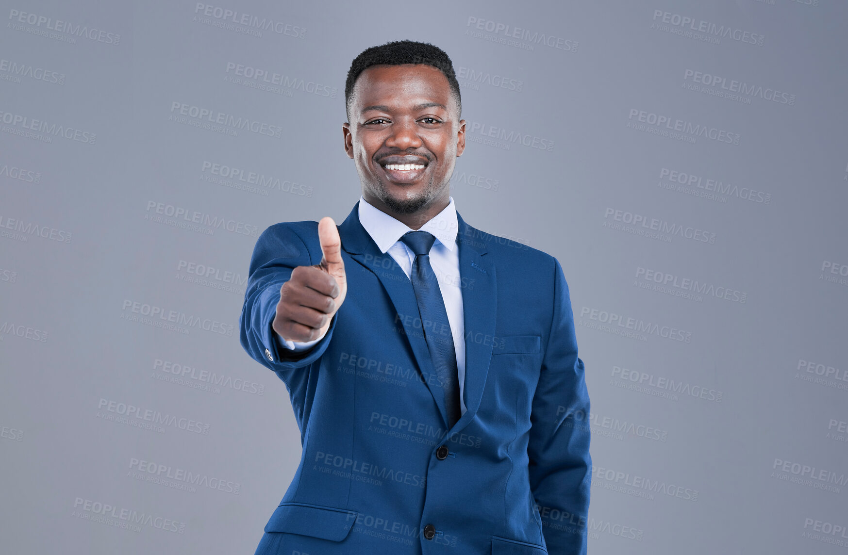 Buy stock photo Cropped portrait of a handsome young businessman giving you a thumbs up in studio against a grey background