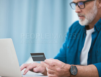 Buy stock photo Shot of a mature businessman using his laptop to make online card payments