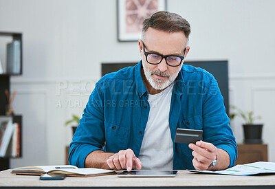 Buy stock photo Shot of a senior businessman using his digital tablet to make online card payments