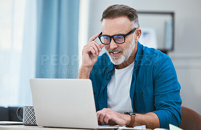 Buy stock photo Shot of a senior businessman working from home while using his laptop