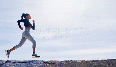 Buy stock photo Shot of a fit young woman out for a run along the beach