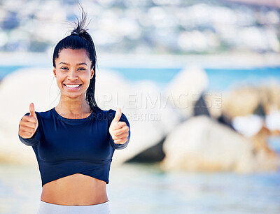 Buy stock photo Shot of a fit young woman showing thumbs up while standing outside