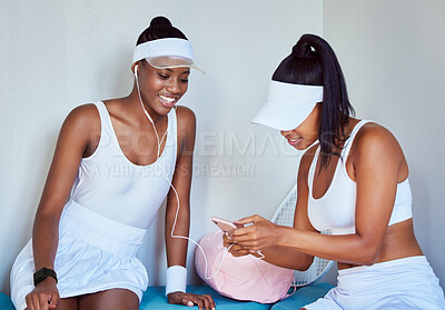 Buy stock photo Shot of two young women listening to music in a locker room