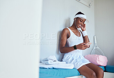 Buy stock photo Shot of a young woman listening to music in a locker room