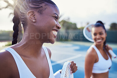 Buy stock photo Shot of two attractive women standing together while playing tennis outside