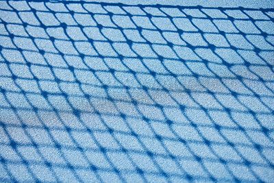 Buy stock photo Shot of a tennis net on an empty court during the day