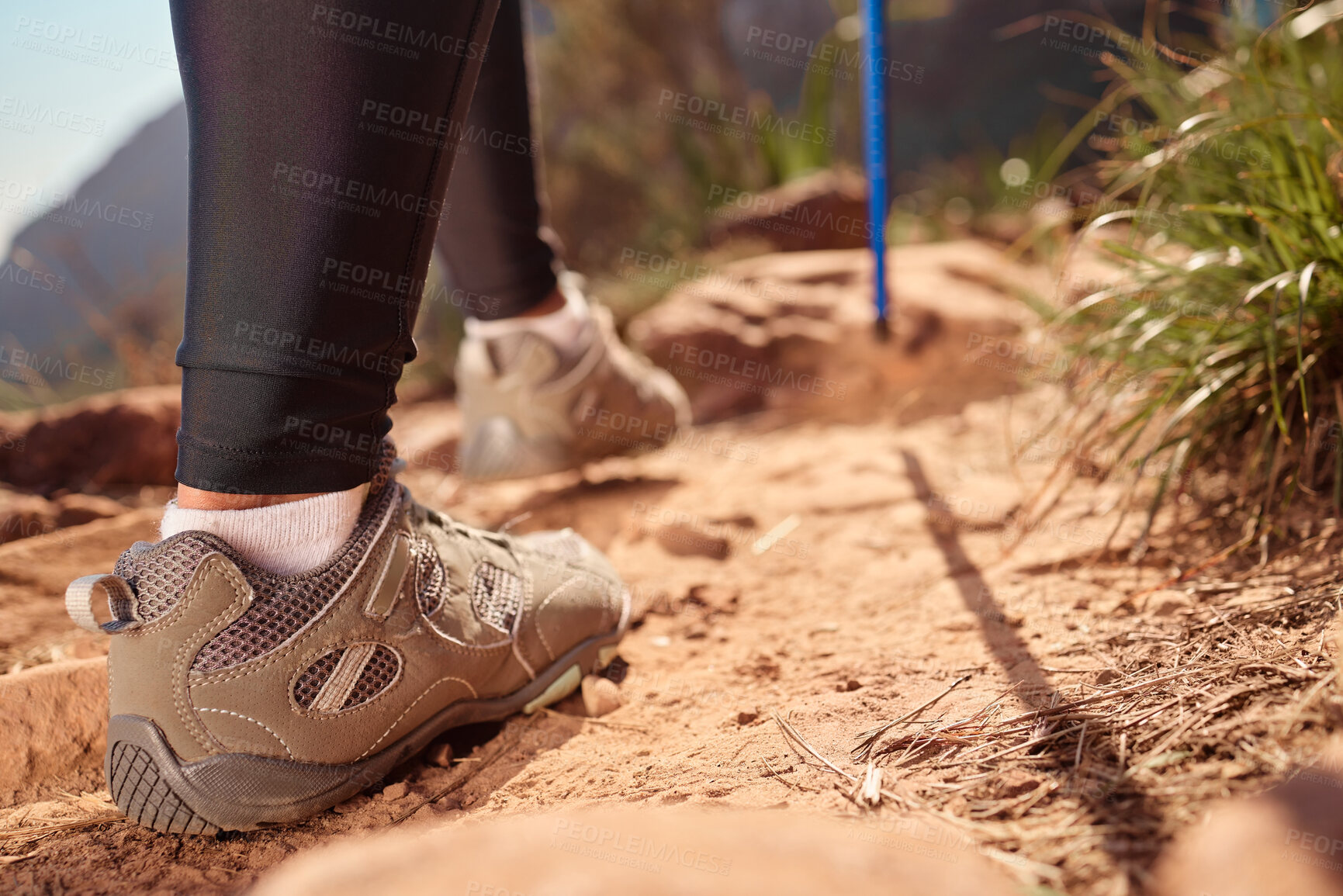 Buy stock photo Feet, hiking and walking pole on ground, direction and safety with balance, fitness and adventure on hill. Person, shoes and stick on mountain, challenge or climbing for workout on path in Argentina