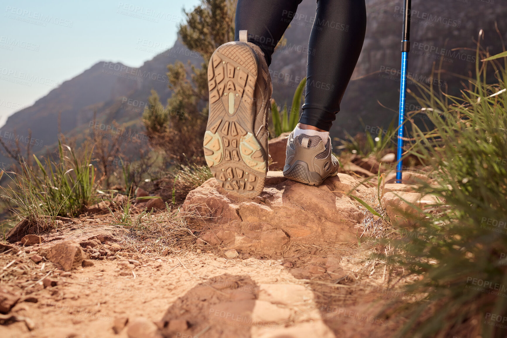 Buy stock photo Feet, hiking and walking pole on path, direction and safety with balance, fitness and adventure on hill. Person, shoes and stick on mountain, challenge or climbing for workout on ground in Argentina