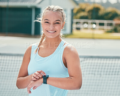 Buy stock photo Shot of an attractive young woman standing alone and checking her watch during tennis practise