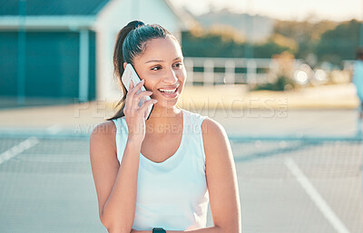 Buy stock photo Shot of an attractive young woman standing alone and using her cellphone after tennis practise
