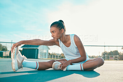 Buy stock photo Full length shot of an attractive young woman sitting alone on a tennis court and stretching before practise