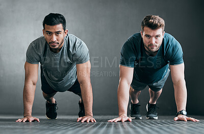 Buy stock photo Full length portrait of two handsome young male athletes planking side by side against a grey background