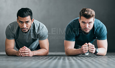 Buy stock photo Full length portrait of two handsome young male athletes planking side by side against a grey background