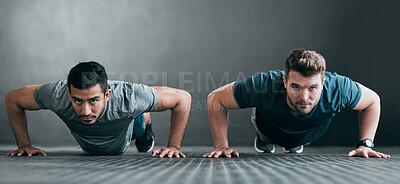 Buy stock photo Full length portrait of two handsome young male athletes doing pushups side by side against a grey background