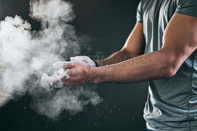 Buy stock photo Cropped shot of an unrecognizable young male athlete applying talcum powder to his hands against a grey background