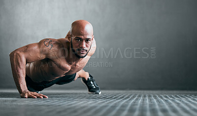 Buy stock photo Full length portrait of a handsome young male athlete doing one-handed pushups against a grey background