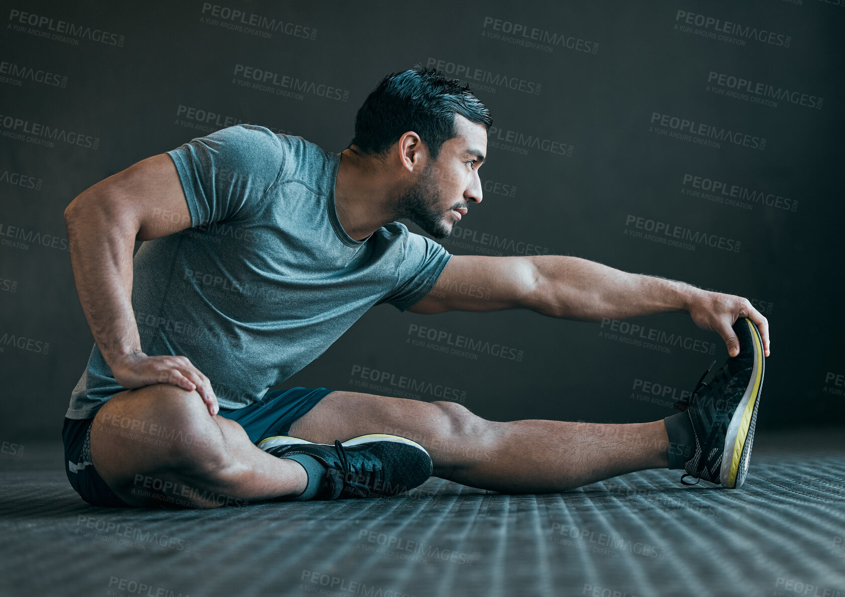 Buy stock photo Stretching legs, fitness and man on floor for exercise, training and warm up for athlete workout. Health, sports and person with muscles for wellness, performance and flexibility on gray background