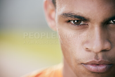 Buy stock photo Cropped shot of a handsome young man looking determined during his outdoor workout