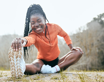 Buy stock photo Full length shot of a young woman sitting and stretching before exercising outdoors