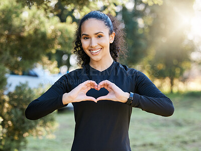 Buy stock photo Portrait of a sporty young woman making a heart shape with her hands while exercising outdoors