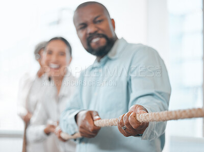 Buy stock photo Cropped shot of a handsome mature businessman and his colleagues pulling on a rope during tug of war in the office