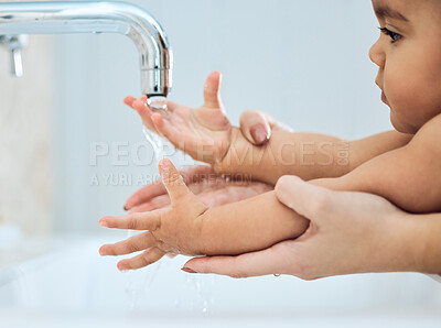 Buy stock photo Shot of a woman washing her baby's hands under running water