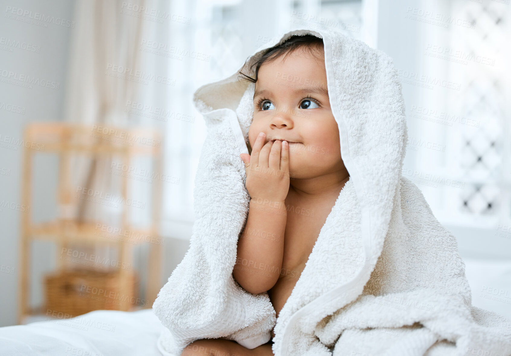 Buy stock photo Shot of an adorable baby covered in a towel after bath time