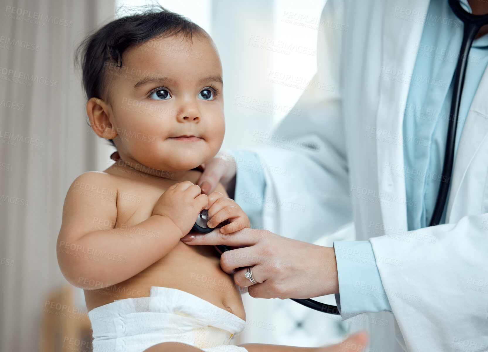 Buy stock photo Closeup shot of a paediatrician using a stethoscope during a baby's checkup in a clinic