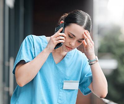Buy stock photo Shot of a young female doctor on a call against a city background