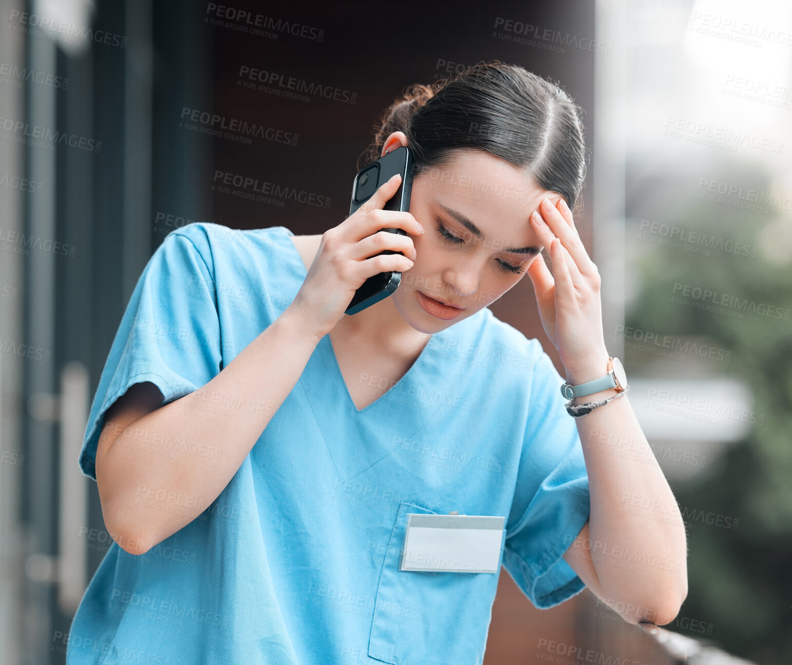 Buy stock photo Shot of a young female doctor on a call against a city background